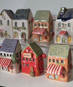 small ceramic houses are lined up on a table