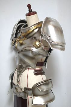 a helmet and armor on display in front of a white wall with a red stripe