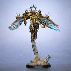 a warhammer standing on top of a pile of sand with wings and two swords