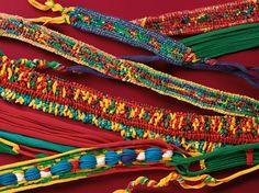 several different colored bracelets on a red surface