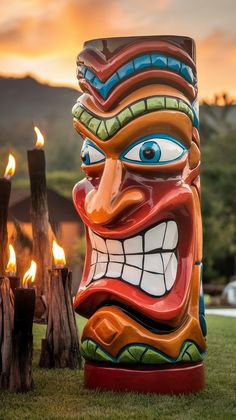 a large tiki statue sitting on top of a lush green field