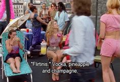 two women sitting in lawn chairs on top of a roof with other people standing around