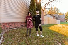 a man and woman standing in front of a house with fake teeth on their faces