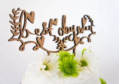 there is a cake that has been decorated with flowers on the top and two wooden letters