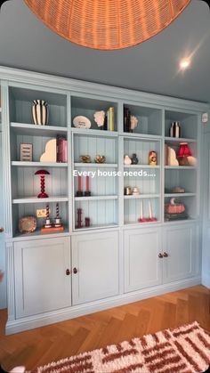 an empty room with blue bookcases and pink rug on the floor in front of it