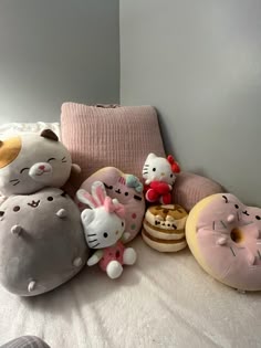 several stuffed animals and doughnuts on a bed