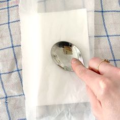 a person is holding a spoon on top of some white napkins and paper towels