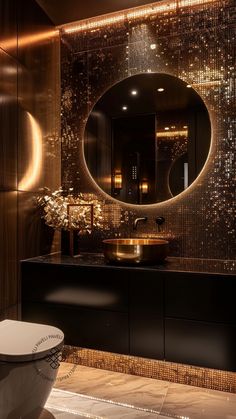 an elegant bathroom with gold sequins on the walls and a round mirror over the sink