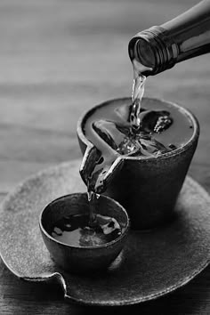 a person pouring water into a bowl on top of a plate