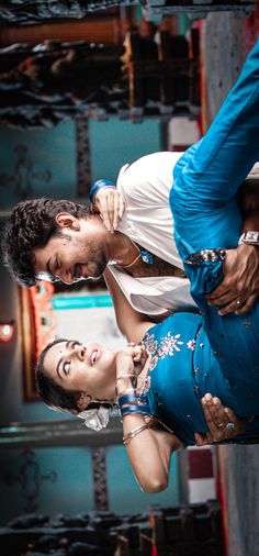 two people standing next to each other in front of a stage with one person holding the other