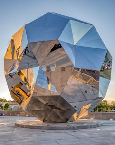 a large metal object sitting on top of a cement slab next to a parking lot