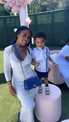 a woman standing next to a little boy