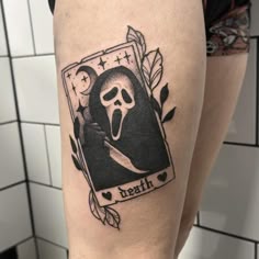 a woman's leg with a tattoo on it that has a ghost holding a knife