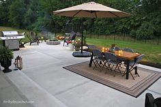 an outdoor patio with table, chairs and grill