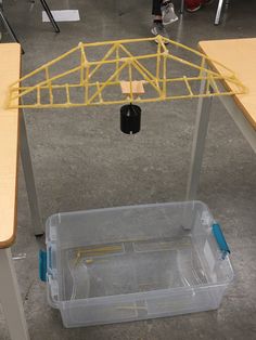 a plastic container sitting on top of a wooden table next to a metal frame structure