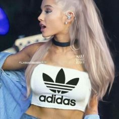 a woman with blonde hair wearing a crop top and jeans