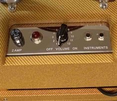 an old amp with some knobs and switches on it's side in a case