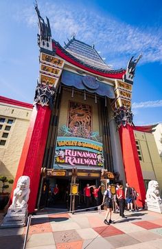 people are standing outside the entrance to an amusement park