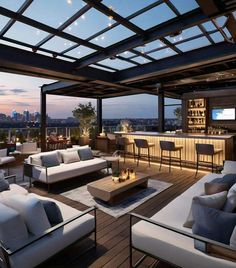 an outdoor living area with couches, tables and bar overlooking the city at night