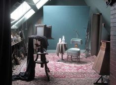 a room filled with furniture and lots of clutter on top of a pink rug