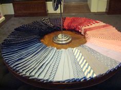 a round table with many different colored ties on it and a flag in the middle