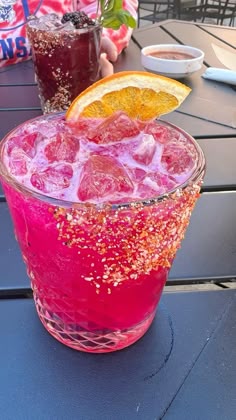 a pink drink with orange slices and sprinkles