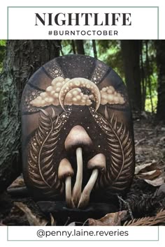 an oval wood slice that has been wood burned and carved to show the moon on top and mushrooms with foliage at the bottom. the background is shaded in with pyrography and the whole image represents life at night.