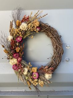 a wreath made with dried flowers in a fall palette