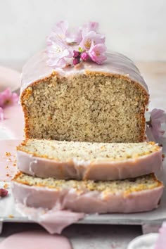 a loaf of cake with frosting and flowers on it sitting on top of a plate