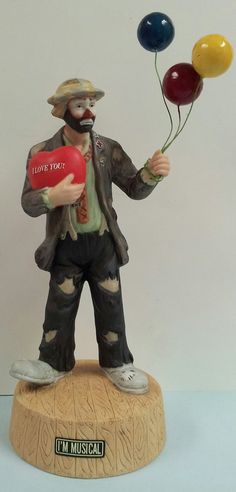 a statue of a clown holding two balloons