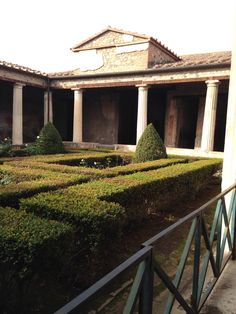 an old building with many bushes in the center