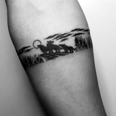 a black and white photo of a man's arm with a wolf tattoo on it