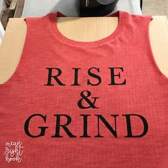 a red tank top with the words rise and grind printed on it next to a soda can