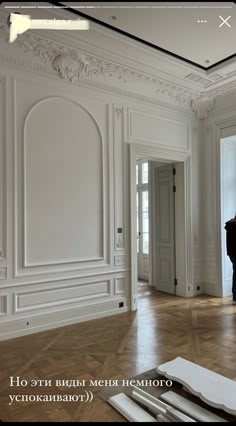 an empty room with white walls and wood flooring is pictured in the foreground