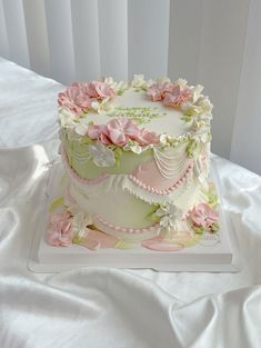 a white cake with pink and green flowers on it