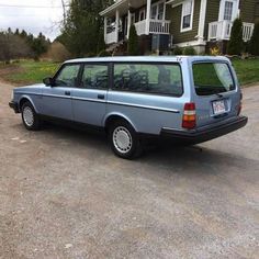 a blue station wagon parked in front of a house