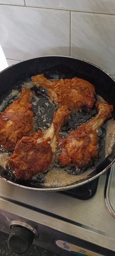 chicken is cooking in a skillet on the stove