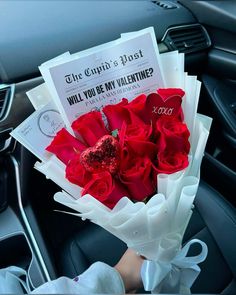 someone is holding a bouquet of roses in their hand while sitting in the driver's seat
