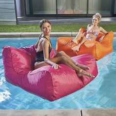 two women sitting on bean bags in the pool