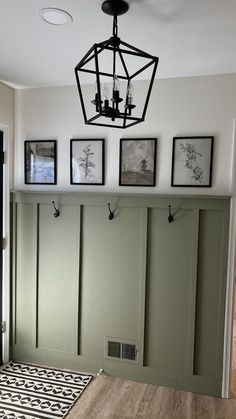 a room with green walls and pictures hanging on the wall above it's door