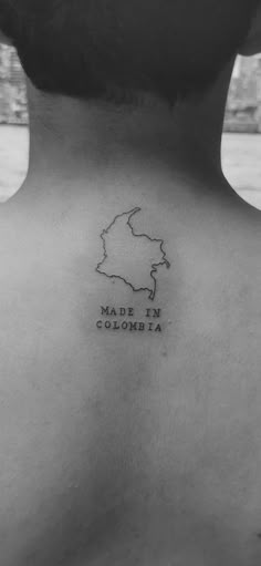 the back of a woman's neck with a map tattoo on her left side