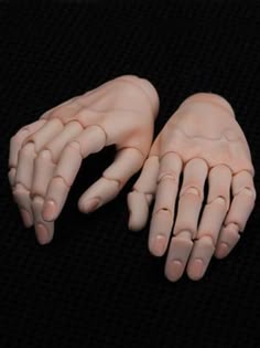 two hands that are sitting next to each other on a black surface with white writing