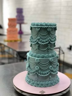 a three tiered cake sitting on top of a plate in front of a table