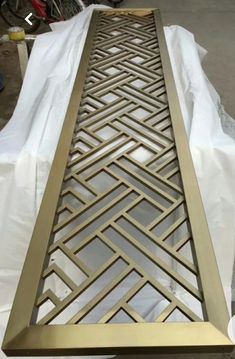 a table that has some kind of metal design on it's side and is covered in plastic