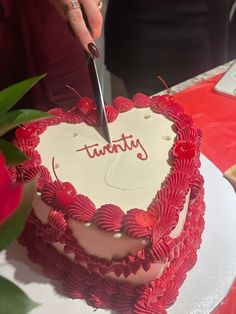 a person cutting into a heart shaped cake with the word trust written on it,