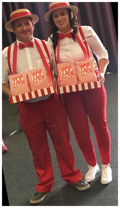 two people dressed in red and white holding boxes