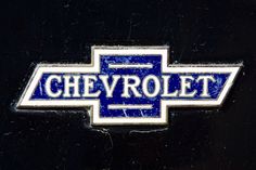 the chevrolet logo is shown in blue and white on a black car's emblem