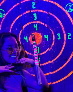 a woman holding a toothbrush in front of a purple and blue background with circles