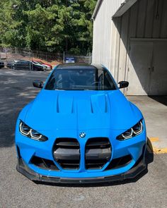 a blue sports car parked in front of a building