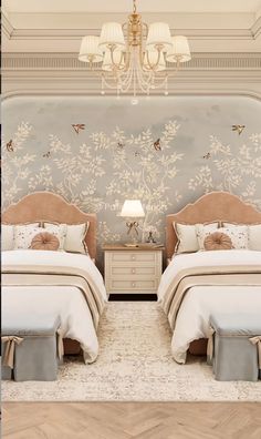 two beds in a room with chandelier and wallpaper on the walls behind them